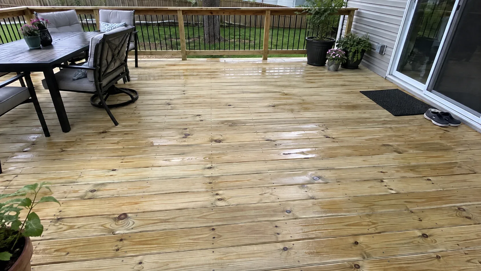 A just finished run of treated pine, knots and a green chemical tint visible, screws countersunk in even rows, a tape measure at the far edge